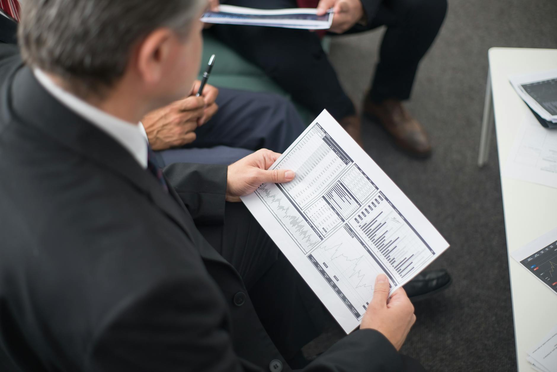 Dwóch przedsiębiorców analizuje dokumenty finansowe przy biurku