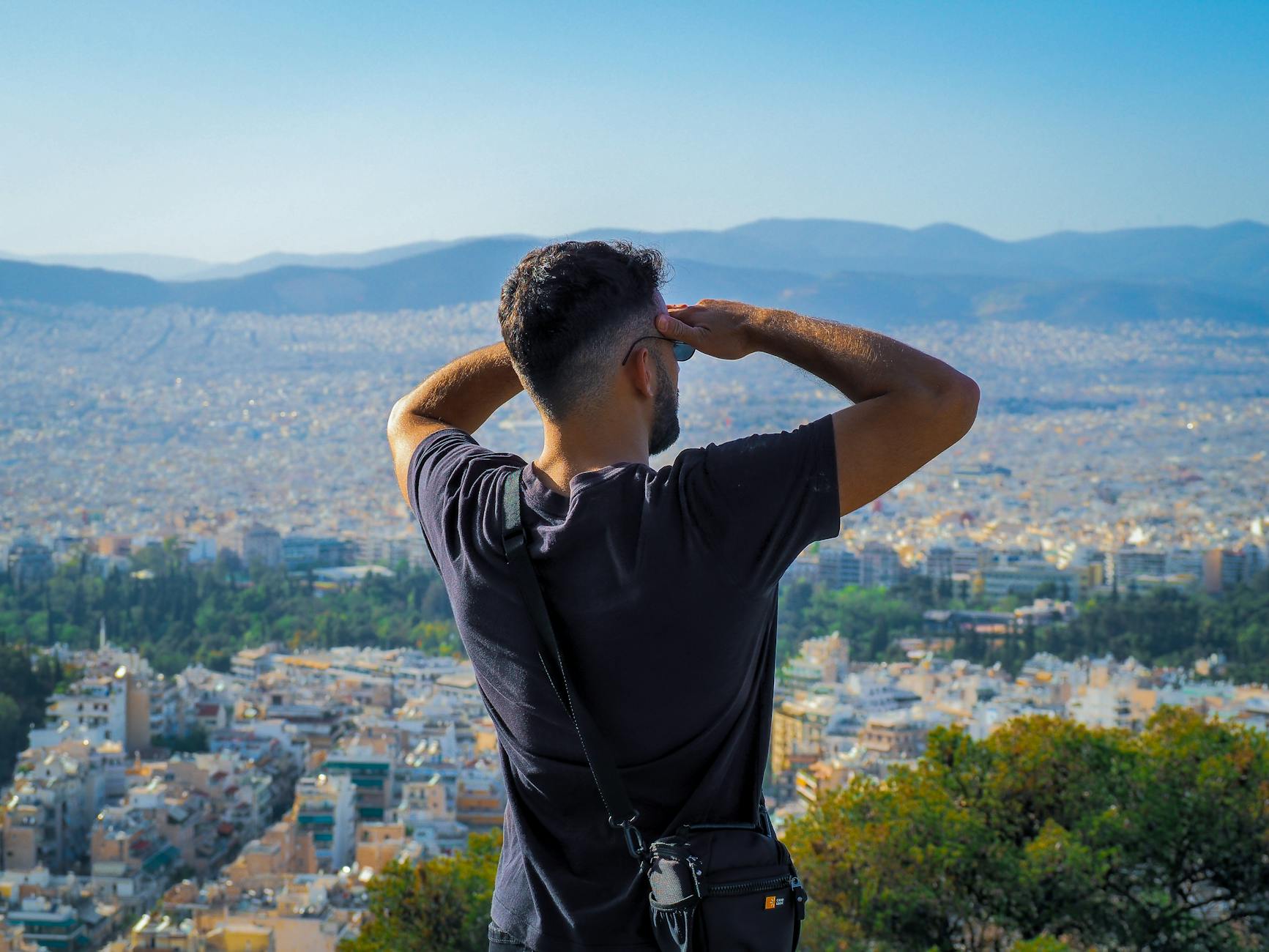Mężczyzna na wzgórzu spogląda na panoramę Warszawy